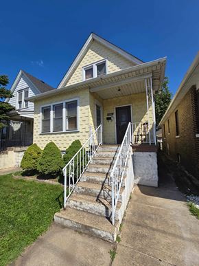 East Chicago house for rent - A yellow house with a white door and windows.
