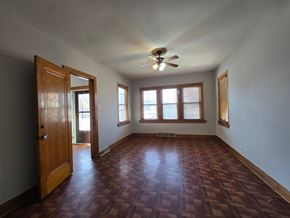 East Chicago house for rent - A room with a wooden floor and a ceiling fan.