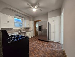 East Chicago house for rent - A kitchen with a black stove top oven and a refrigerator.