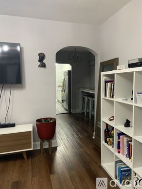 Washington apartment for rent - A living room with a television, a bookshelf, and a plant.
