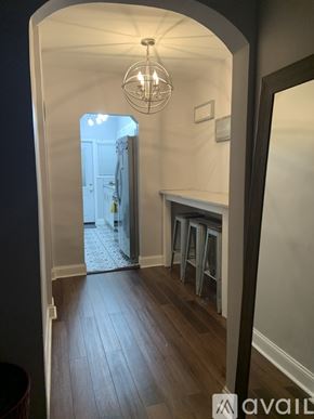 Washington apartment for rent - A hallway with a light hanging from the ceiling and a doorway leading to another room.
