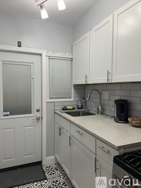Washington apartment for rent - A kitchen with white cabinets and a black and white floor mat.