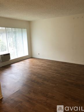 Glendale apartment for rent - A room with wooden flooring and a window with blinds.