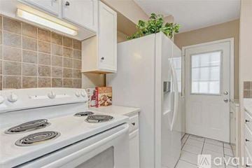 Seabrook house for rent - A kitchen with a white stove top oven and white cabinets.