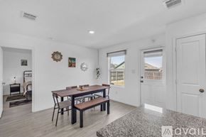 New Braunfels house for rent - A kitchen with granite countertops and a dining area with a table and chairs.