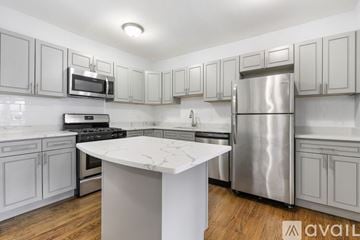 Chicago apartment for rent - A kitchen with a white island and stainless steel appliances.