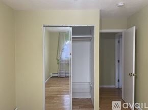 Winthrop apartment for rent - A room with a white door and a mirror showing a bedroom.