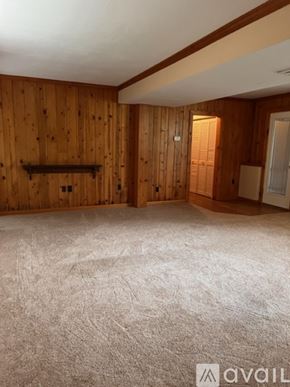 Pittsburgh apartment for rent - A room with wooden walls and a carpeted floor.
