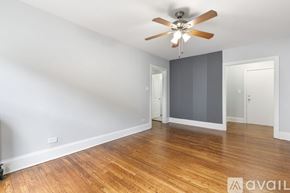 Chicago apartment for rent - A room with a ceiling fan and wooden flooring.