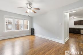 Chicago apartment for rent - A room with a ceiling fan and wooden floors.