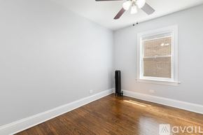 Chicago apartment for rent - A room with a ceiling fan, a window with blinds, and a wooden floor.