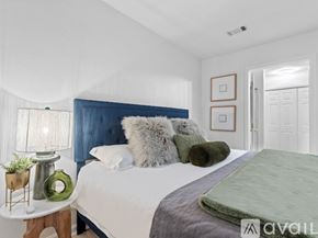 Tallahassee townhouse for rent - A bedroom with a white bed and a blue headboard.