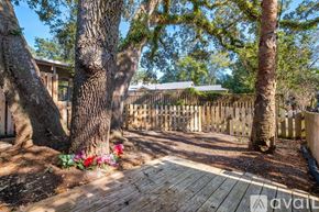 Tallahassee townhouse for rent - A wooden deck is surrounded by trees and a fence.