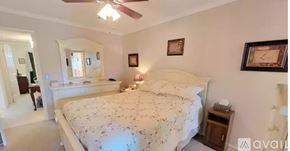 Clearwater condo for rent - A bedroom with a large bed and a ceiling fan.