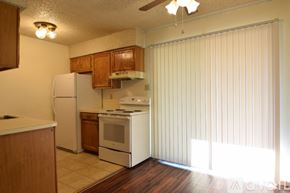 Belton house for rent - A room with wooden floors and a white wall with a door.