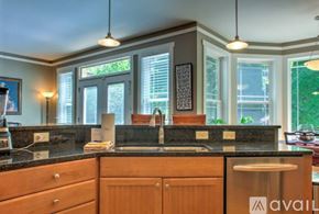 Asheville house for rent - A kitchen with wooden cabinets and a black countertop.