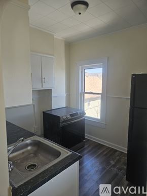 Scranton apartment for rent - A kitchen with black appliances and a window.