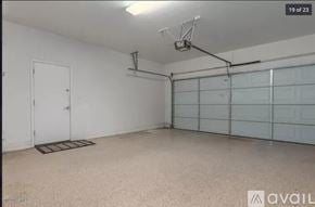 Phoenix house for rent - A spacious garage with a white door and a wall of windows.