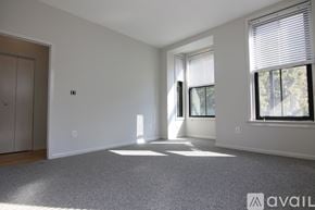 Boston apartment for rent - A spacious room with a carpeted floor and a large window with blinds.