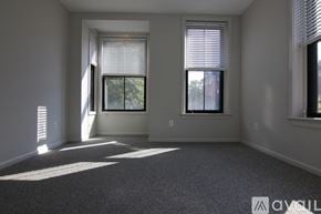 Boston apartment for rent - A sunny room with two windows and a carpeted floor.