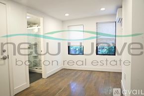 Boston apartment for rent - A room with a door open to a balcony with a view of trees.