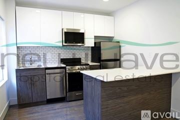 Boston apartment for rent - A kitchen with a stove top oven and a microwave above it.