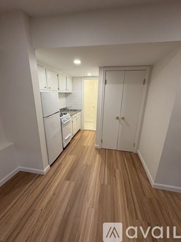 Boston apartment for rent - A kitchen with white cabinets and a wooden floor.