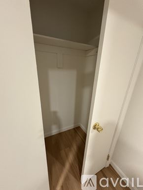 Boston apartment for rent - A white door with a gold handle is in a room with wooden floors.