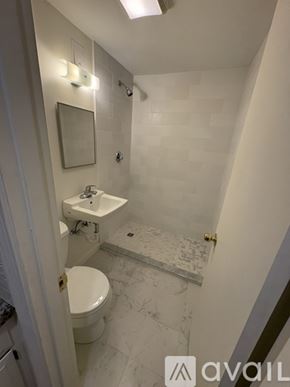 Boston apartment for rent - A bathroom with a toilet, sink, and mirror.