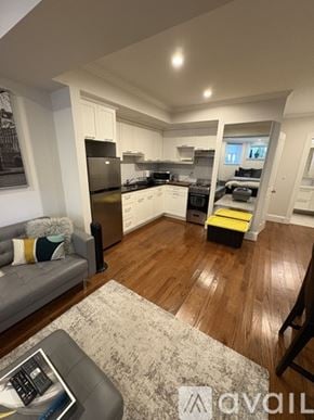 Boston apartment for rent - A modern kitchen with wooden floors and a grey sofa with a throw pillow.