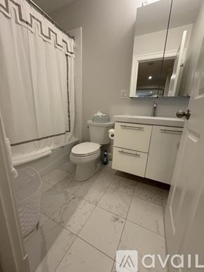 Boston apartment for rent - A white bathroom with a toilet, sink, and shower.