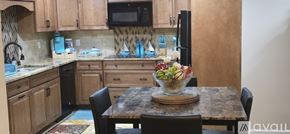 Vine Grove apartment for rent - A kitchen with wooden cabinets and a black refrigerator.