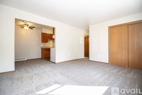 Rossford apartment for rent - A spacious room with a ceiling fan and a door leading to another room.