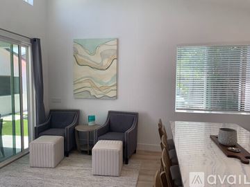 Huntington Beach apartment for rent - A living room with a grey sofa, ottoman, and a painting on the wall.