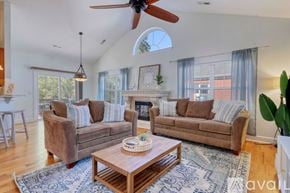 Myrtle Beach house for rent - A living room with a brown couch, a coffee table, and a ceiling fan.