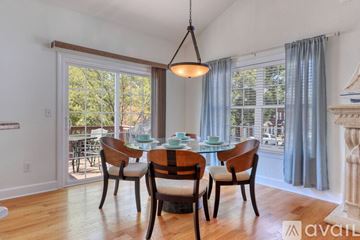 Myrtle Beach house for rent - A dining room with a table set for four and a view of the backyard.