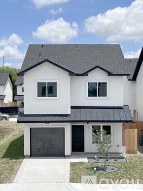 Edinburg townhouse for rent - A white house with a black roof and a black garage door.