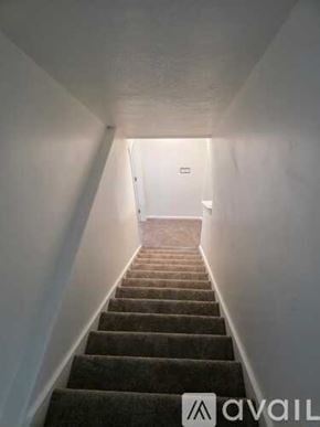 Tooele townhouse for rent - A staircase with a carpeted runner and white walls.