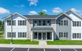 Carlisle apartment for rent - A modern two-story building with a stone facade and a grey roof.