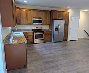 Harrisburg townhouse for rent - A kitchen with wooden cabinets and a granite countertop.