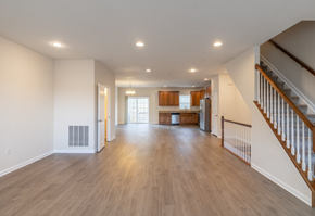 Harrisburg townhouse for rent - A spacious living room with hardwood floors and a staircase on the right side.