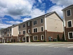 Middletown apartment for rent - A large building with a parking lot in front of it.