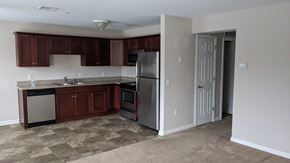 Middletown apartment for rent - A kitchen with brown cabinets and a refrigerator.