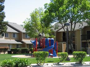 Antioch apartment for rent - A playground with a blue slide in front of a building.