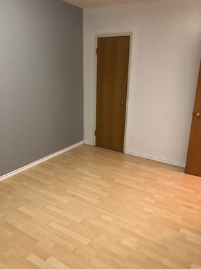 Swift Current apartment for rent - A room with a wooden floor and a brown door.