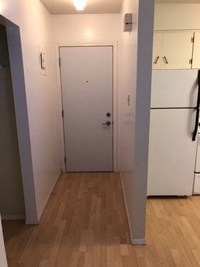 Swift Current apartment for rent - A white door is in a room with wood flooring.