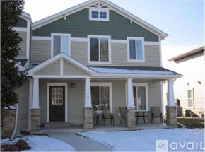 Sheridan townhouse for rent - A house with a green and grey exterior and a black door.