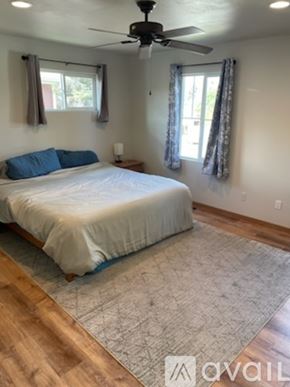 Sheridan townhouse for rent - A bedroom with a bed, a ceiling fan, and a rug.