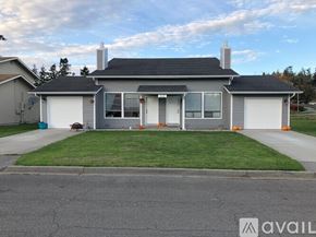 Anacortes apartment for rent - A house with a grey roof and white walls is for sale.