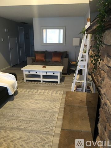 Anacortes apartment for rent - A living room with a white coffee table and a stone wall.